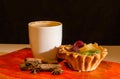 Cup of coffee with a cake, cinnamon and anise on an orange tray