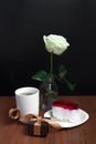 A cup of coffee with a cake and a rose on a black background. Valentine`s Day Royalty Free Stock Photo