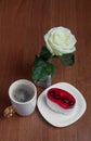 A cup of coffee with a cake and a rose on a wooden background. Valentine`s Day Royalty Free Stock Photo