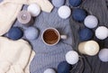 Cup of coffee and candles, garlands on pastel background