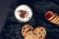 Cup of coffee, cappuccino with chocolate cookies and biscuits on black table background. Afternoon break time. Breakfast. Top view Royalty Free Stock Photo