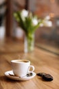 Cup of coffee, car remote key and vase of flowers on wooden table in coffee shop, selective focus. The concept of Royalty Free Stock Photo