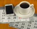 Cup of coffee, cell phone, calendar on wooden table Royalty Free Stock Photo