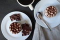 Cup of coffee and chocolate cakes on a white plate on a black background Royalty Free Stock Photo