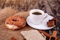 Cup of coffee with chocolate, donuts  and cinnamon sticks  on wooden background Royalty Free Stock Photo