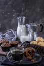 A cup of coffee, chocolate muffins, cheese breads and milk