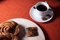 Cup of coffee with chocolate on the side. Crispy brown baked biscuits with black sesame seeds on wooden board. Coffee break bites
