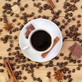 Cup of coffee, chocolate, sugar, spices and coffee beans on a wooden background Royalty Free Stock Photo