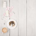 Cup of coffee, cigarettes, medical bottles and pills on white wooden table