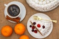 Cup of coffee, cinnamon, fork and slice of biscuit cake decorated with whipped cream and raspberries Royalty Free Stock Photo