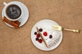 Cup of coffee, cinnamon, fork and slice of biscuit cake decorated with whipped cream and raspberries Royalty Free Stock Photo