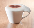Cup of coffee with cinnamon heart on milk foam