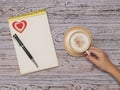 A Cup of coffee with cinnamon and milk and a notebook on a wooden table. Flat lay. Royalty Free Stock Photo