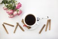 A cup of coffee cinnamon and roses on a white background morning Royalty Free Stock Photo