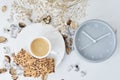 Cup of coffee and classic alarm clock on a white table. Autumn or winter cozy background. Hygge style Royalty Free Stock Photo