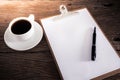 Cup of coffee and clipboard with blank page and pen Royalty Free Stock Photo