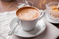 Cup of coffee close-up with spoon,  saucer and brown sugar  bowl on wooden table Royalty Free Stock Photo