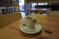 Cup of coffee close-up on the wooden table across cafe interior. Macchiato Royalty Free Stock Photo