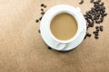 Cup of coffee with coffee beans on burlap warm cup on brown background top view Royalty Free Stock Photo