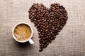 Cup of coffee and coffee beans in shape of heart