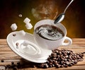 Cup of coffee, coffee beans and sugar cubes falling on the table Royalty Free Stock Photo