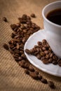 Cup of coffee with coffeebeans on linen material.