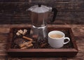 Cup of coffee, coffeepot, biscuit, cinnamon, anise, sugar, coffee beans on wooden tray