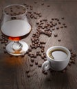 Cup of coffee, cognac glass and coffee beans