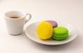 Cup of coffee with colorful macaron cakes in white plate on white table Royalty Free Stock Photo