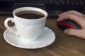 A cup of coffee computer, mouse, hand, wooden background mouse