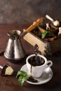 Cup of coffee with cooffee beans, wooden box with grains of coffee and spices, cezve on a stone background Royalty Free Stock Photo