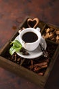 Cup of coffee with cooffee beans on a wooden box with grains of coffee and spices on a stone background Royalty Free Stock Photo