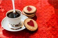 Cup of coffee and a cookie with a heart of marmalade