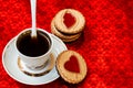Cup of coffee and a cookie with a heart of marmalade