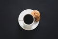 Cup of coffee and cookies on a black background, top view. Royalty Free Stock Photo