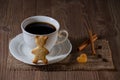 A cup of coffee and cookies like bear and heart with cinnamon, coffee beans on wooden table