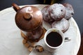 A cup of coffee, a copper coffee pot and chocolate muffins