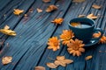 a cup of coffee on a country wooden table with orange marigolds and leaves