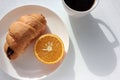 Cup of coffee, croissant and orange on white background. Top view, copy space. Morning espresso on table. Healthy breakfast. Royalty Free Stock Photo