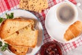 Cup of coffee and croissant on saucer, glass bowl with strawberry jam, cookies with whole grains of sunflower seeds and toasted s Royalty Free Stock Photo