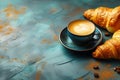 Cup of coffee with croissants on blue textured background with copy space. Traditional french breakfast. Royalty Free Stock Photo