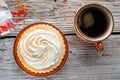 cup of coffee with delicious cream cake with orange beads around white old style wooden background. close up. lifestyle concept Royalty Free Stock Photo