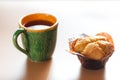 cup of coffee and delicious fresh muffin on table