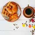 Cup of coffee and delicious pastries on a wooden background