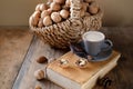 Cup of coffee, different kinds of nuts, walnut, hazelnuts, almonds on old wooden table boards, edible seed kernels, food concept, Royalty Free Stock Photo