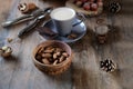 Cup of coffee, different kinds of nuts, walnut, hazelnuts, almonds on old wooden table boards, edible seed kernels, food concept, Royalty Free Stock Photo