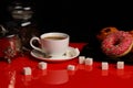 Cup of coffee with donut and sugar on a red glossy table Royalty Free Stock Photo