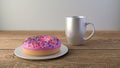 Cup with coffee and donut on a wooden table