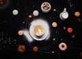 Cup of coffee,  donuts, macaroons, sugar, milk cream jug and cakes on black background look like coffee system Royalty Free Stock Photo