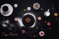 A cup of coffee, donuts, macaroons, sugar, milk cream jug and cakes on black background look like coffee system Royalty Free Stock Photo